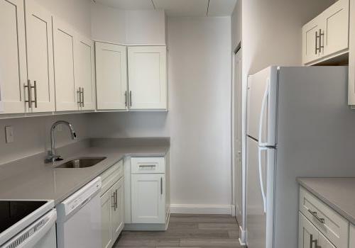 a kitchen with white cabinets and white appliances - Elkins Park Terrace