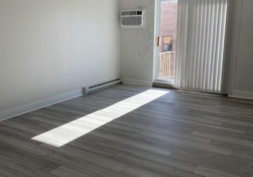 在一间白色墙壁和木地板的房间里，空调机组放在木地板上