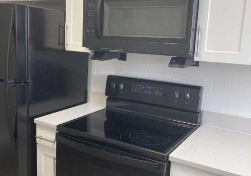现代厨房，白色石英台面和黑色烤箱